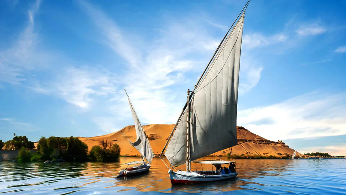 Felucca sail against Elephantine Island on a short Aswan Nile cruise at sunset
