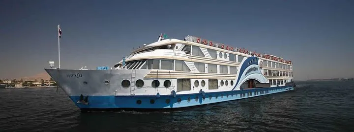 Ship cruising past palm banks on a 5-day private Nile river cruise from Luxor to Aswan