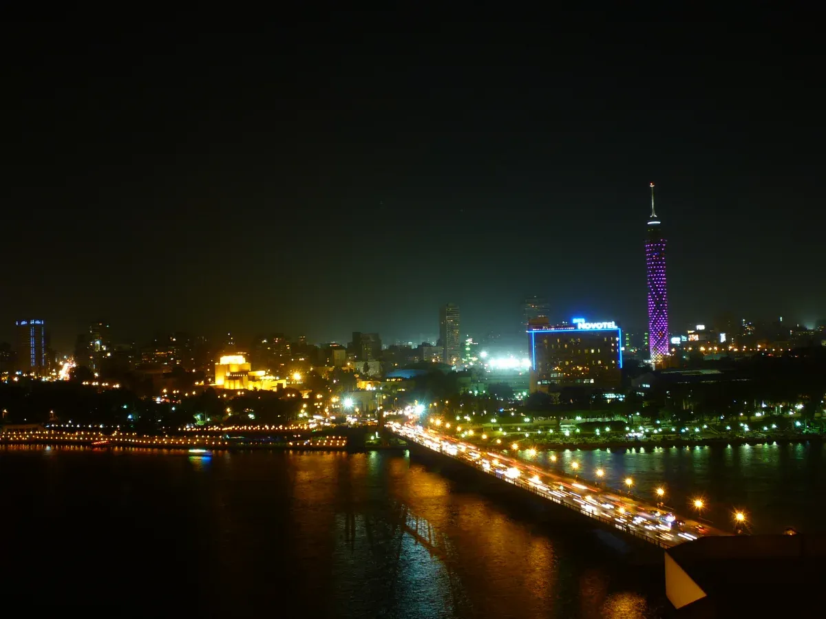 The Nile and the lit Cairo Tower at night, the setting of a Nile dinner cruise in Cairo