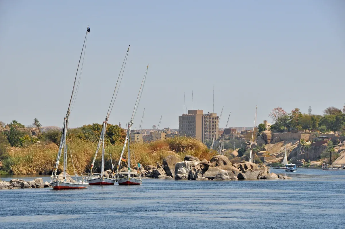 Feluccas moored on the granite rocks of the Nile at Aswan in winter light on a Nile river cruise